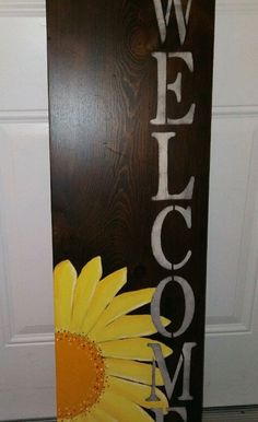 a welcome sign with a yellow flower on it