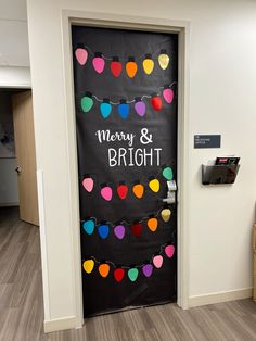 a door decorated with christmas lights and merry and bright written on the front doors to an office