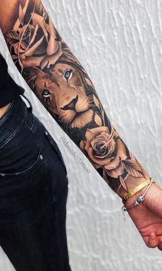 a man with a tattoo on his arm holding the hand of a woman's forearm