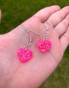 Each pair of sparkly neon pink heart earrings are handmade to order, therefore no two pairs are identical! Every resin jewelry piece in my shop is slightly unique and one of a kind! However, I try to get as close to the listing photos as possible :) Made with nickel-free, hypoallergenic, sterling silver plated fishhooks earrings.  Hearts are approximately 19mm, and are made with epoxy resin and neon pink chunky holographic glitter ✨ UV Blacklight reactive! Perfect for raves, festivals, Valentine's Day, etc. Color may vary slightly. Thanks for visiting my shop! 💖 Rave Earrings, Earrings Hearts, Pink Heart Earrings, Rave Accessories, Pink Sparkly, Festival Accessories, Rave Festival, Fish Hook Earrings, Holographic Glitter