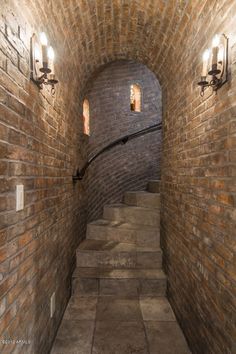 an old brick tunnel with stairs and lights