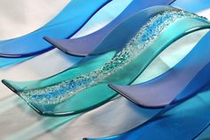 some blue and purple glass pieces on a white table