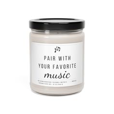 a candle that says fair with your favorite music on the front and bottom, surrounded by a black lid