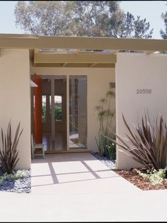 an entrance to a building with plants and trees