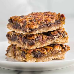 three pieces of granola bar stacked on top of each other on a white plate