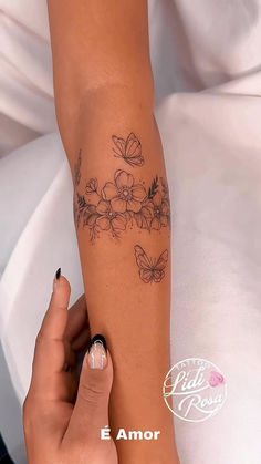 a woman's arm with flowers and butterflies on it