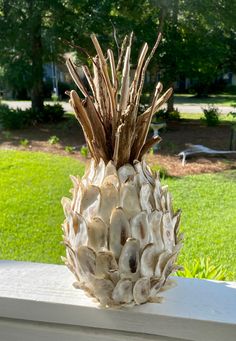 a pineapple sitting on top of a white table in front of a green field