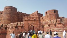 people standing in front of a large brick building