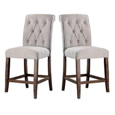 a pair of grey upholstered barstools with buttons on the backrests