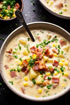 two bowls filled with soup and topped with bacon, corn, and green garnish