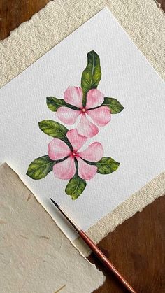 a watercolor painting of pink flowers with green leaves on white paper next to a brush