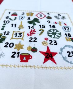 a cross stitch christmas table runner with numbers and ornaments on it's border,