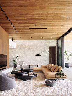 a modern living room with wooden ceiling and white carpet