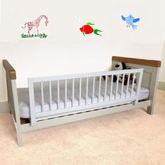 a baby crib with two stuffed animals on the wall