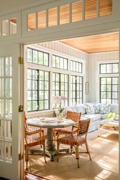 the sun shines through the windows into a living room with chairs and a table