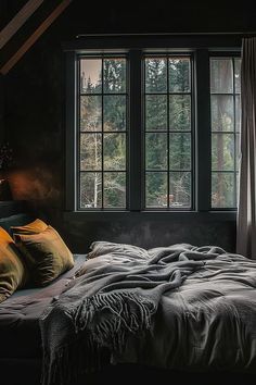 a bed sitting next to two windows in a bedroom