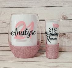 two personalized wine glasses with pink glitter on the bottom and one has an age