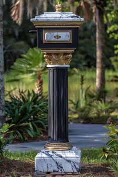 a black and gold clock on top of a white marble pillar in the middle of a park