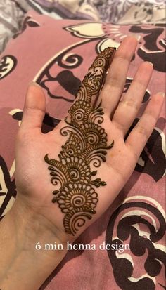 someone is holding their hand up with henna designs on the top and bottom of it