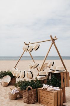 hats and baskets are arranged on the beach