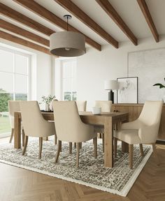 a dining room table with beige chairs and a rug on the floor in front of it