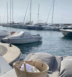 several sailboats are docked in the water at a marina with gray cushions and pillows