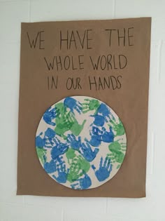 a paper plate with hand prints on it that says we have the whole world in our hands