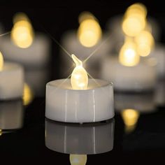 some white candles with yellow lights on them