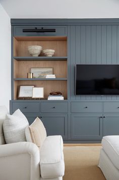 a living room filled with furniture and a flat screen tv on top of a wooden entertainment center