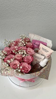 pink roses and baby's breath in a gift basket with personal care items on the table