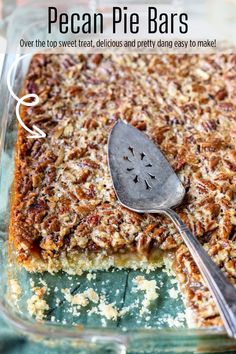 pecan pie bars in a glass baking dish with a serving spoon