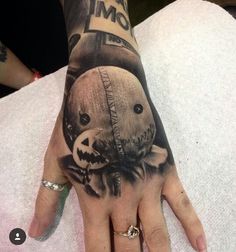 a person's hand with a tattoo on it that has an image of a teddy bear and jack - o - lantern