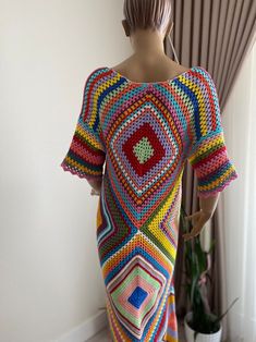 a mannequin wearing a multicolored crocheted dress