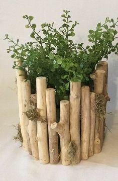 a planter made out of wood sticks with plants growing in the top and bottom