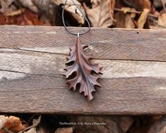 an oak leaf is hanging from a chain