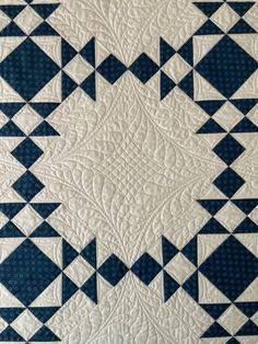 a blue and white quilt with triangles on it