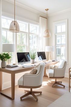 an office with two computer screens on the desk and chairs in front of them,