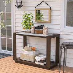 a table with some plants on top of it next to a chair and potted plant