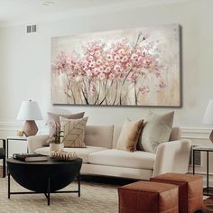 a living room filled with furniture and a large painting on the wall above it's coffee table