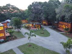 an aerial view of several houses in the woods at dusk, with trees and shrubs surrounding them