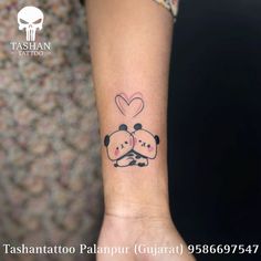 a couple of panda bears hugging each other on the wrist with hearts in the background