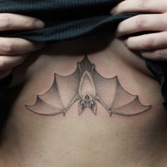 a woman with a bat tattoo on her stomach