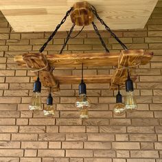 a chandelier made out of wooden planks with lights hanging from the ceiling