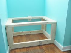 a wooden shelf sitting on top of a hard wood floor next to a blue wall