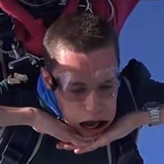 a man is upside down in the air with his hands on his face and mouth open