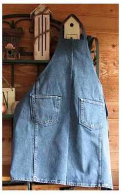 a blue jean bib hanging on a wall next to a shelf with birdhouses