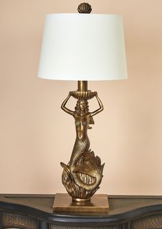 a lamp that is sitting on top of a table in front of a dresser with drawers