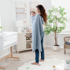 a woman standing in a room with a baby