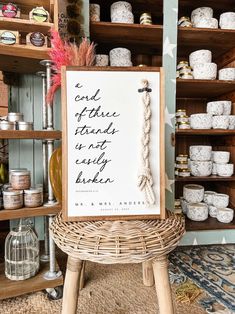 a sign sitting on top of a wicker chair next to shelves filled with jars