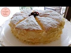 a cake sitting on top of a white plate covered in powdered sugar and cherries